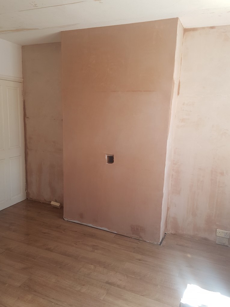 The same chimney breast after restoration, fully skimmed and finished with new flooring laid